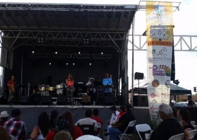 Photo of band playing on stage while people dance