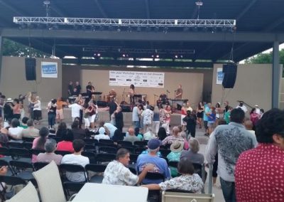 Photo of a band playing music on stage while people dance