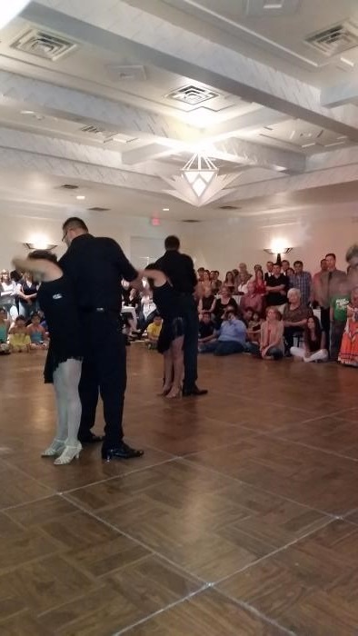observers watch two couples dance on a dance floor