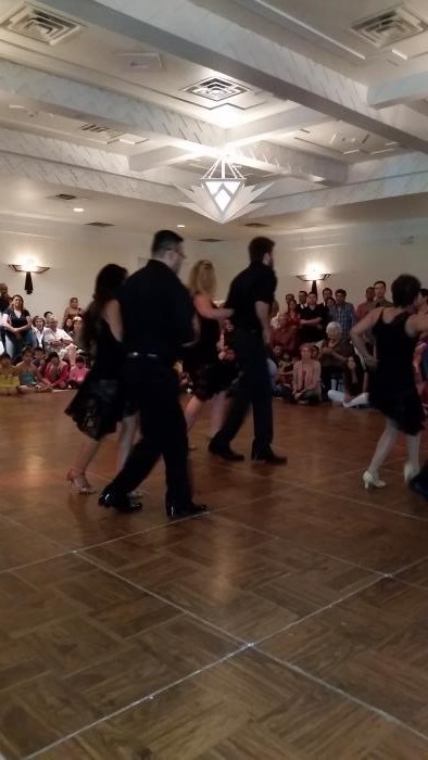observers watch several couples dance on a dance floor
