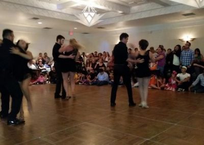 observers watch several couples dance on a dance floor