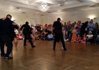 observers watch several couples dance on a dance floor