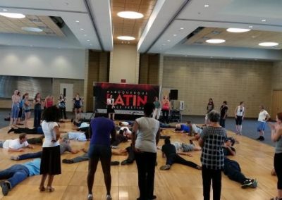 Dance floor full of people laying on the ground while spectators watch