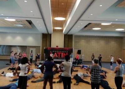 Dance floor full of people laying on the ground while spectators watch