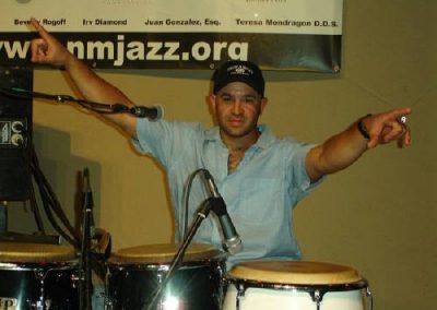 drummer behind conga drums, posing for a photo