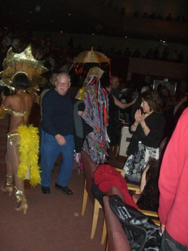photo of man walking through crowd of dancers
