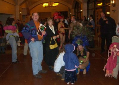 woman with peacock hat speaking to a child