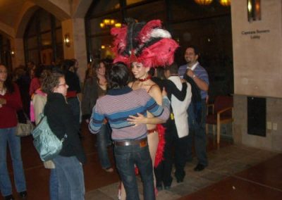 man dancing with woman with a big feather hat