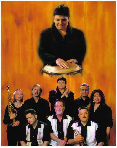 band posing for photo with instruments. Conga player is above them all, looking at them