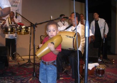 a child carries a mini-conga drum